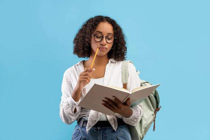 Nigerian student holding books, thinking about which course to study in 2026/2027